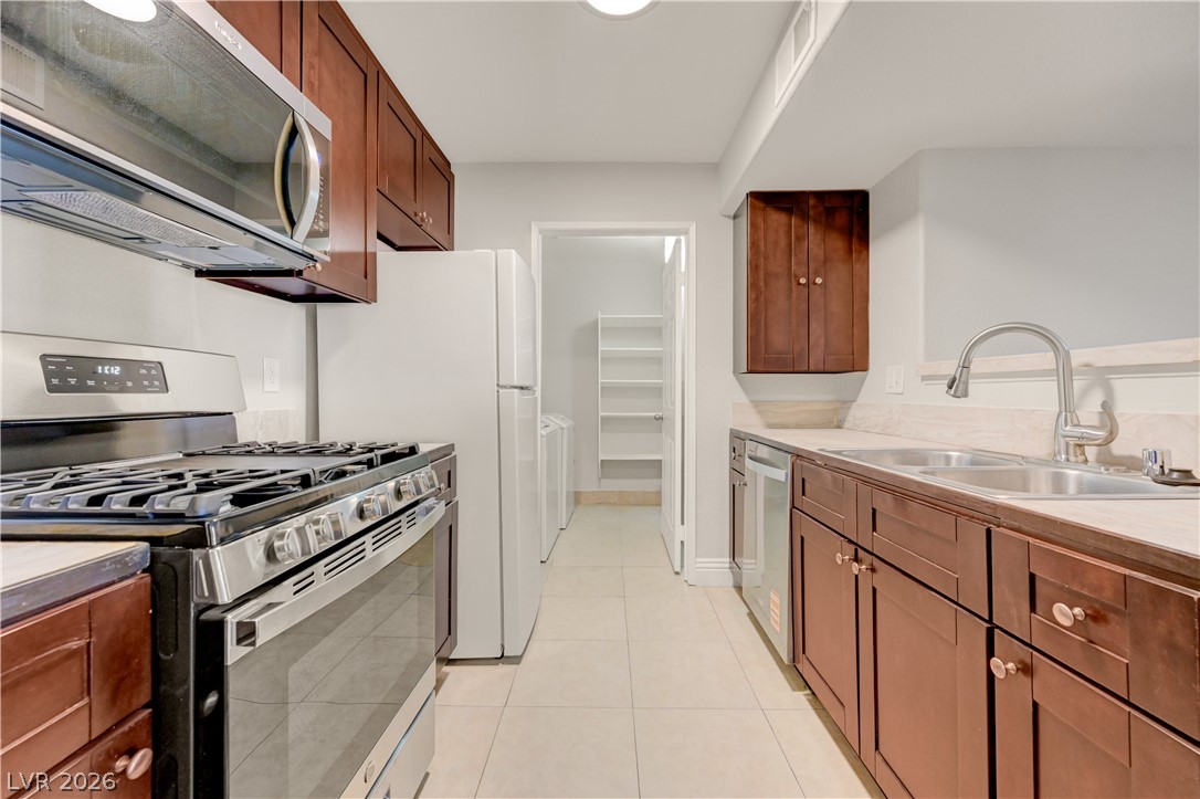 7885 West Flamingo Road, Unit 1050 Las Vegas, NV 89147 - Photo 15 of 62 A galley kitchen with rich wood cabinetry and essential appliances for everyday culinary endeavors.