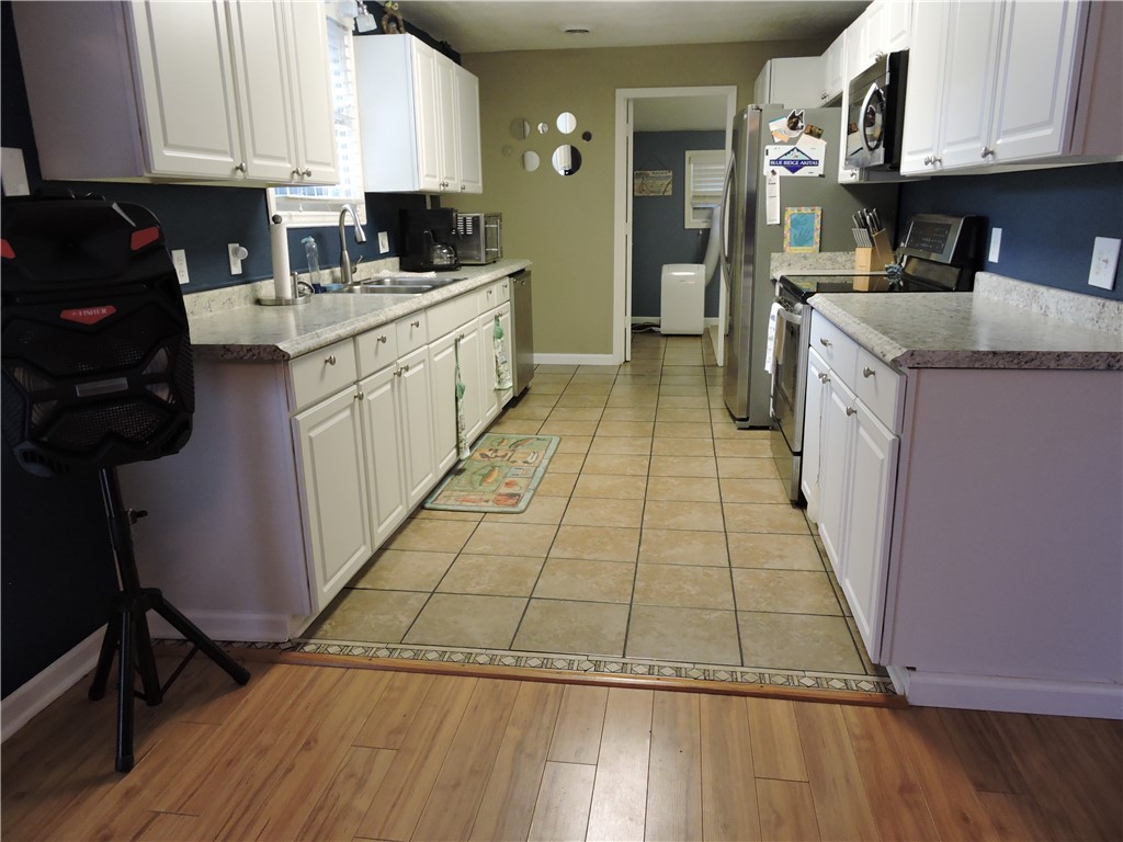 1901 Hattons Ford Road Townville, SC 29689 - Photo 13 of 33 A galley kitchen with pristine white cabinetry, stainless steel appliances, and a seamless flow from the living area.