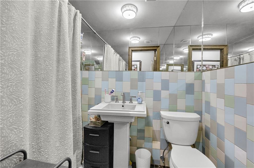 1030 Greene Avenue Brooklyn, NY 11221 - Photo 3 of 19 a bathroom with a sink mirror vanity and toilet