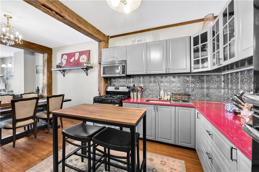 1030 Greene Avenue Brooklyn, NY 11221 - Photo 4 of 19 a kitchen with a sink a stove and chairs