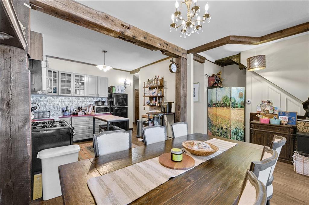 1030 Greene Avenue Brooklyn, NY 11221 - Photo 10 of 19 a view of a dining room and livingroom with furniture wooden floor a chandelier