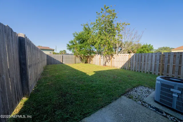 a view of a backyard with wooden fence
