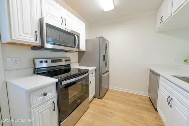 a kitchen with stainless steel appliances a stove microwave and refrigerator