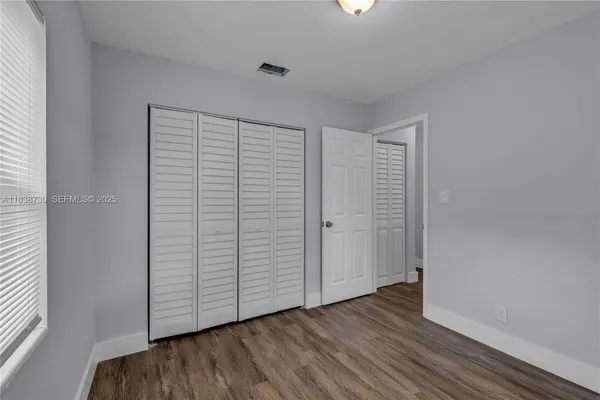 an empty room with wooden floor and closet