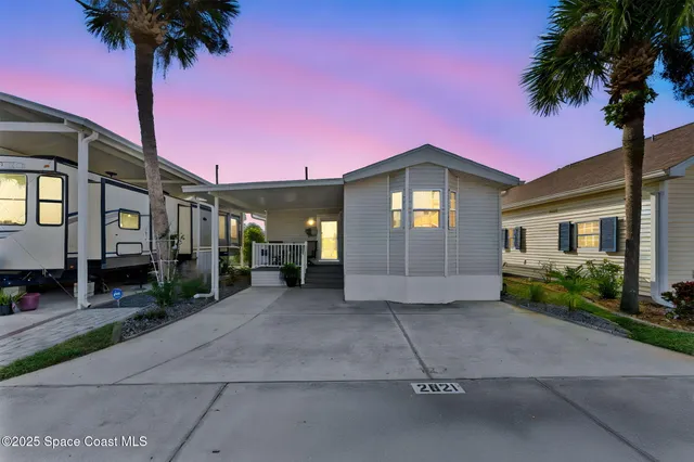 a front view of a house with a garden and trees