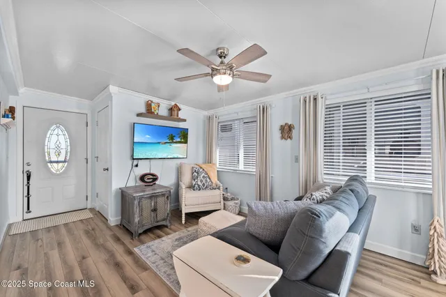 a kitchen with stainless steel appliances granite countertop a refrigerator a sink dishwasher a stove and white cabinets with wooden floor