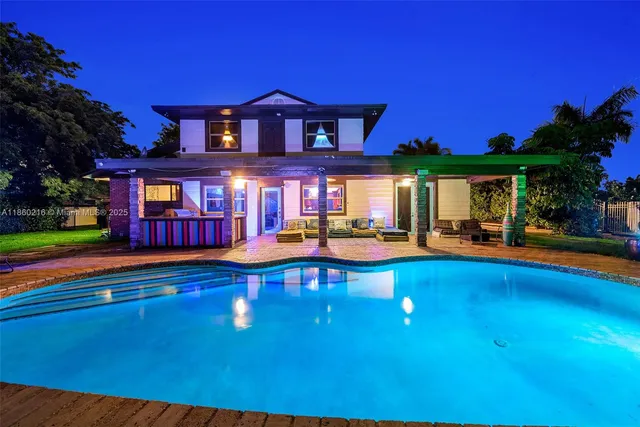 a view of swimming pool with lawn chairs and plants