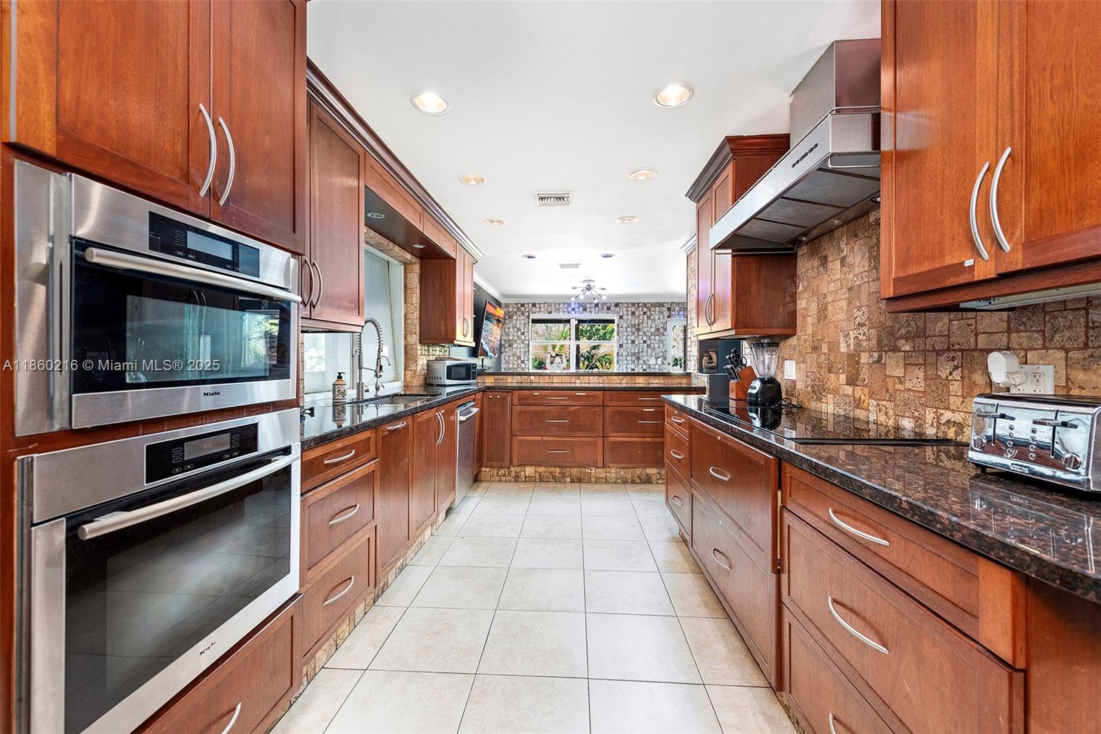 250 Northeast 158th Street Miami, FL 33162 - Photo 13 of 80 a large kitchen with stainless steel appliances granite countertop a stove a sink and a microwave