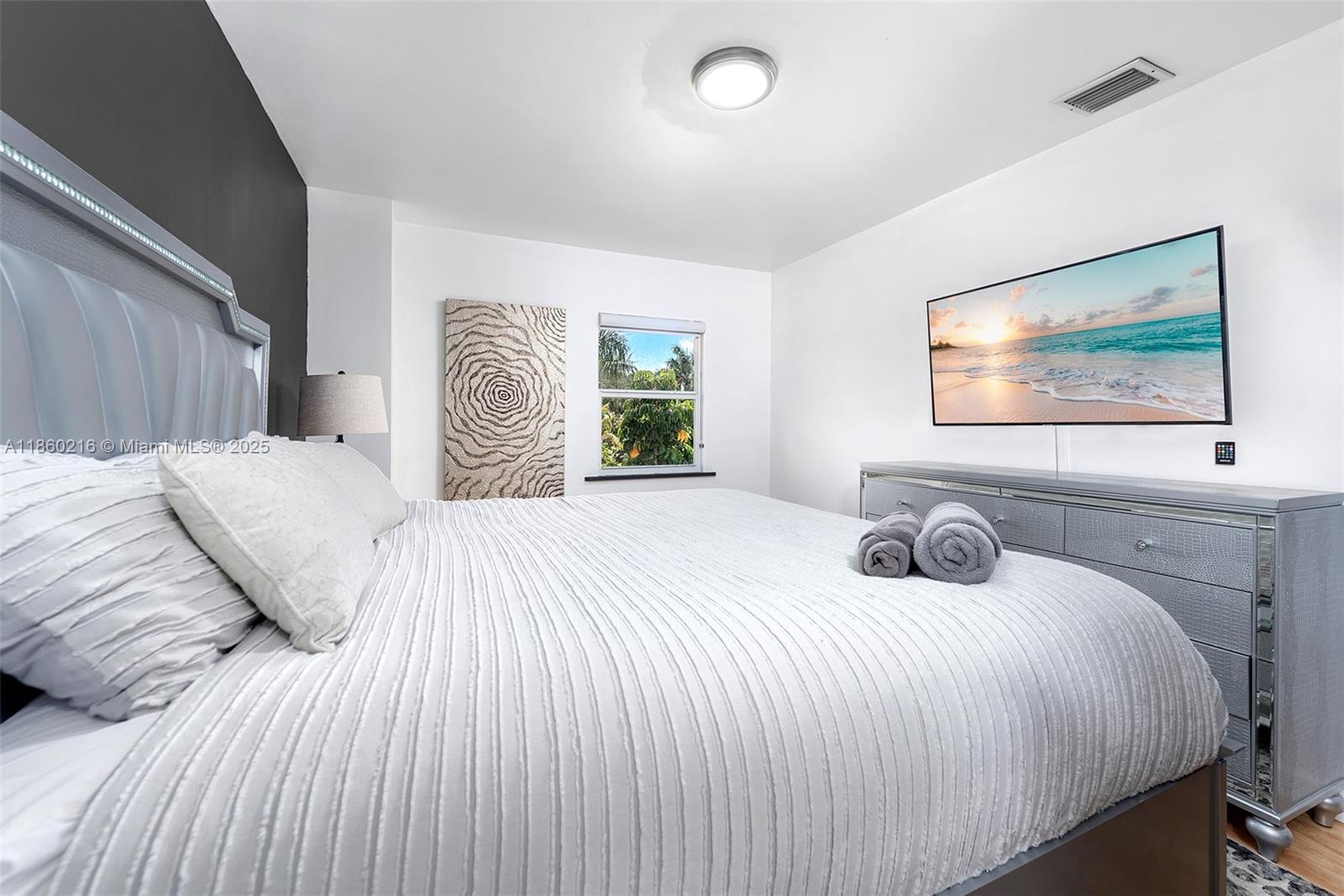 250 Northeast 158th Street Miami, FL 33162 - Photo 28 of 80 a bedroom with a bed and a painting on the wall