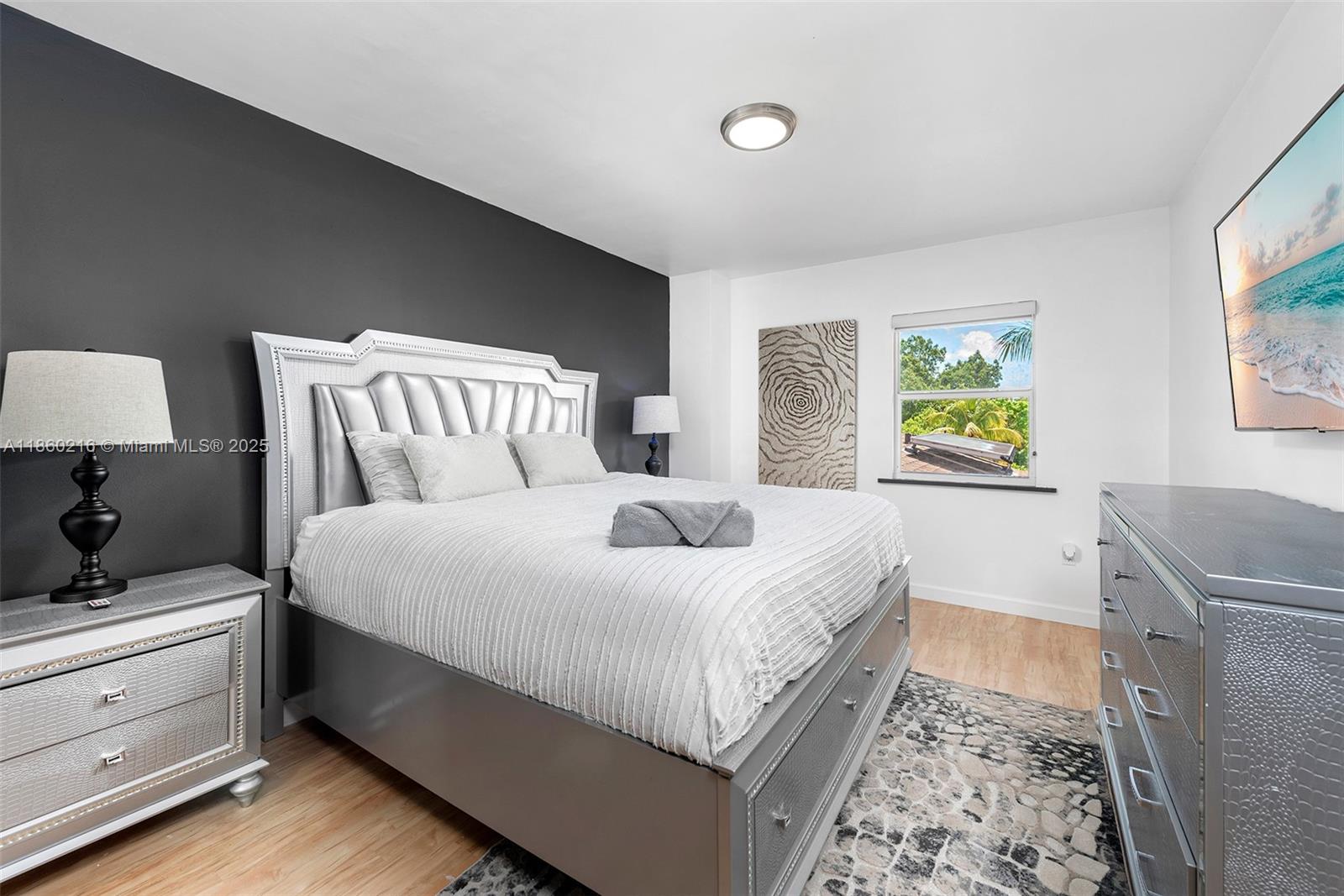 250 Northeast 158th Street Miami, FL 33162 - Photo 29 of 80 a bedroom with a bed and a lamp on dresser