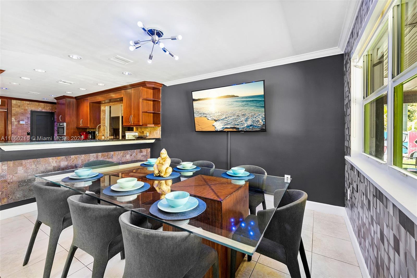 250 Northeast 158th Street Miami, FL 33162 - Photo 47 of 80 a dining room with furniture a rug and a chandelier