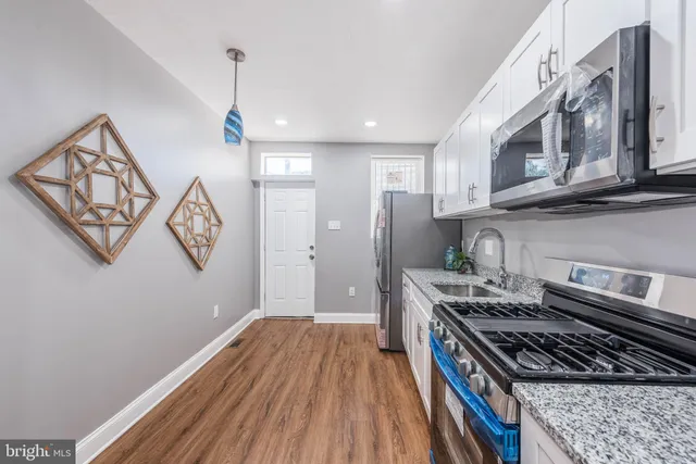 a kitchen with stainless steel appliances granite countertop a stove and a wooden cabinets