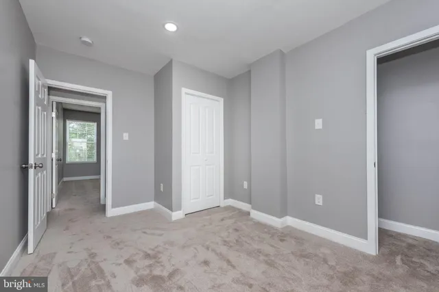 an empty room with closet and a bathroom