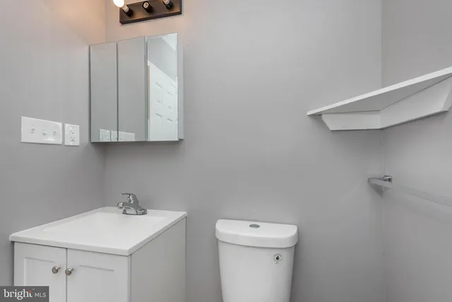 a bathroom with a sink a toilet and vanity