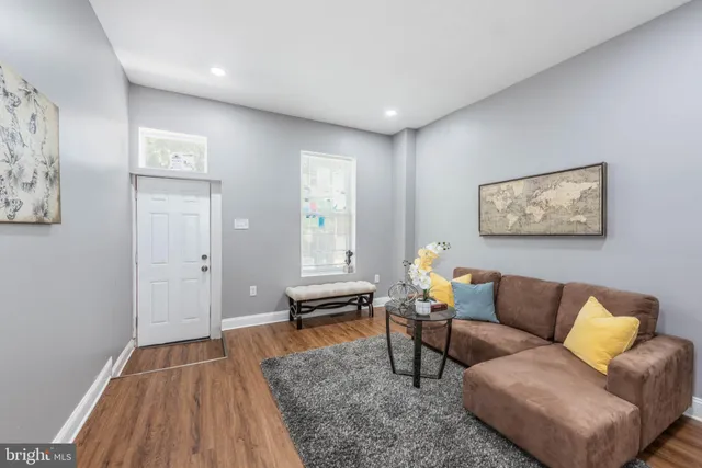 a living room with furniture and a wooden floor