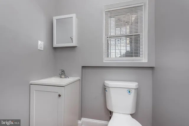 a bathroom with a sink a toilet and a window