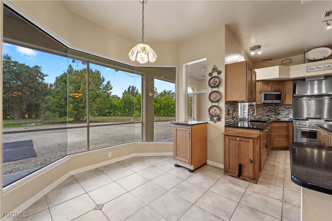 2050 Snyder Drive Alva, FL 33920 - Photo 20 of 49 a open kitchen with stainless steel appliances granite countertop a stove a sink dishwasher and white cabinets with wooden floor
