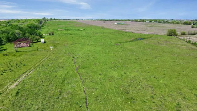a view of a green field with an ocean view