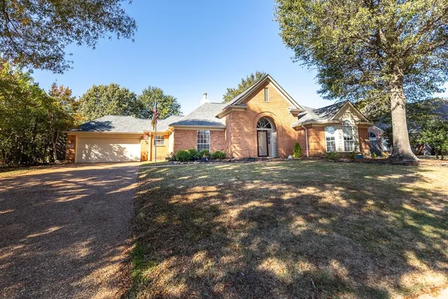 a front view of a house with a yard and trees