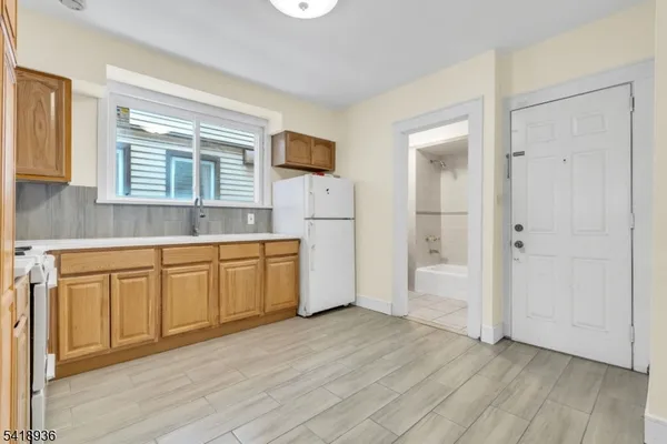 a kitchen with white cabinets and wooden floors