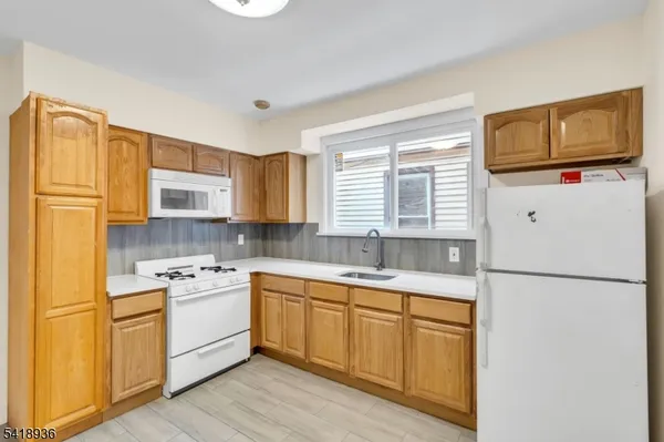 a kitchen with a sink a refrigerator a stove and cabinets