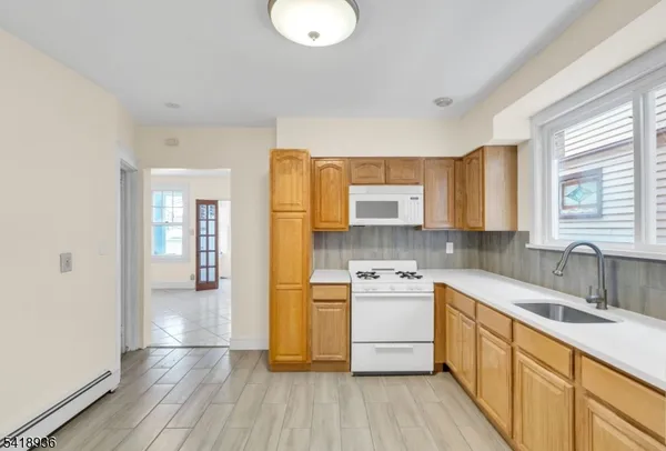 a kitchen with a sink wooden floor and stainless steel appliances