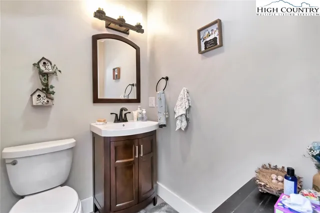 a bathroom with a sink mirror toilet and vanity