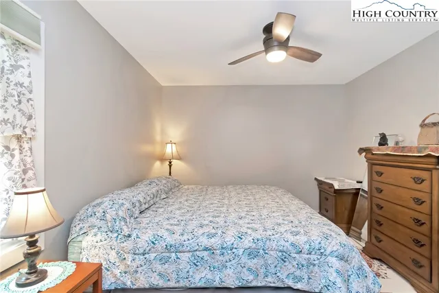 a bedroom with a bed and a lamp on the dresser