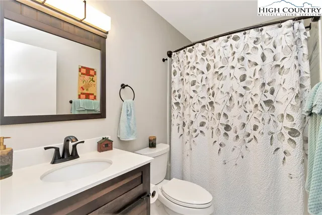 a bathroom with a sink vanity mirror and toilet
