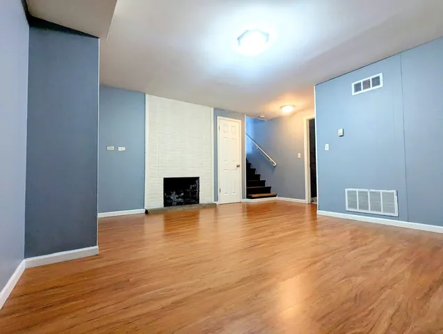 a view of empty room with wooden floor and fireplace