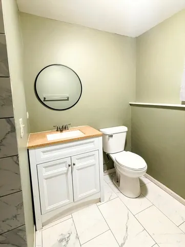 a bathroom with a toilet sink and mirror