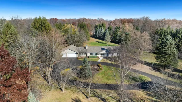 a aerial view of a house with a yard lake and mountain view in back