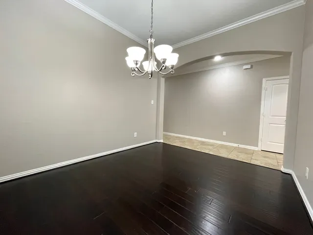 a view of a room with wooden floor and chandelier