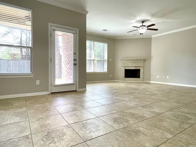 a view of an empty room with a fireplace and a window