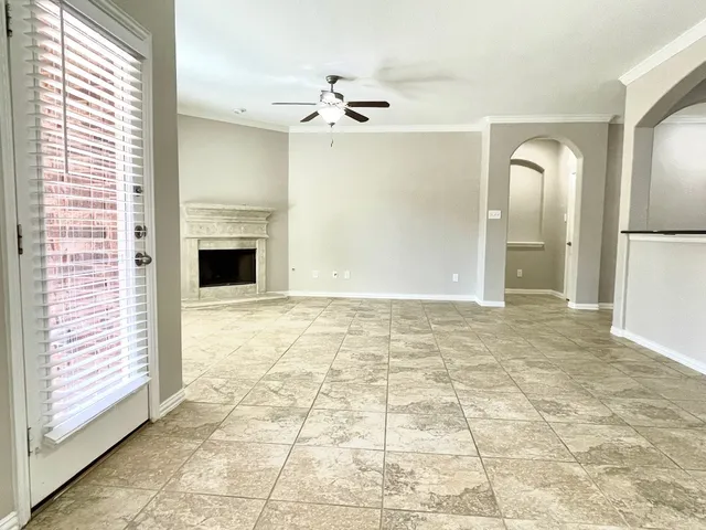 a view of empty room with a fireplace and windows