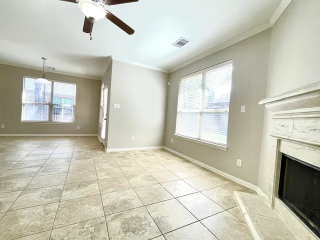 a view of an empty room with a fireplace and a window