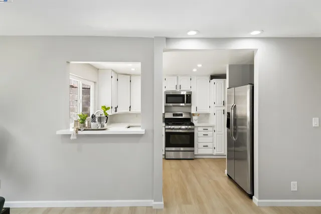 a kitchen with stainless steel appliances a refrigerator and a stove top oven