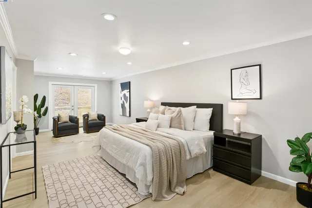 a spacious bedroom with a bed a couch and potted plant