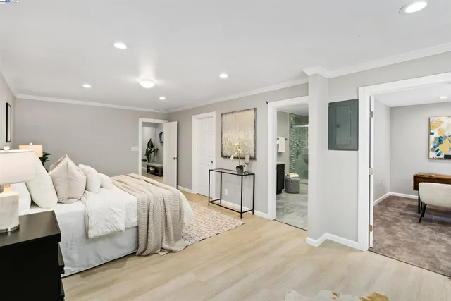 a bedroom with a large bed and wooden floor