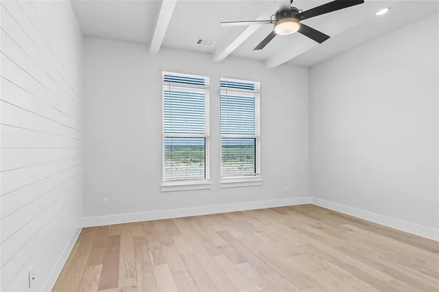 an empty room with a window and a ceiling fan