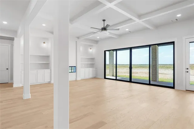 a view of an empty room with a window and a ceiling fan