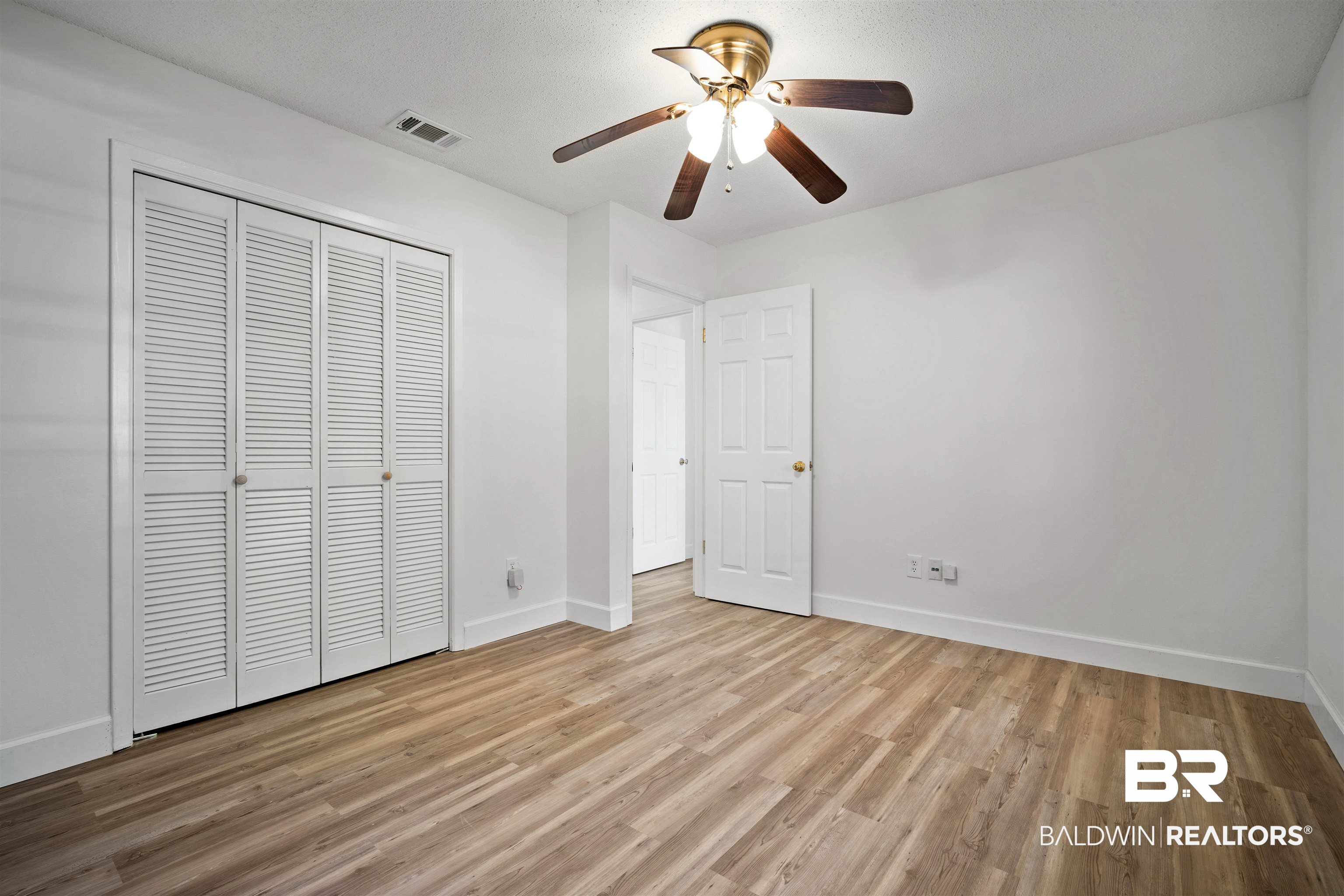 6521 Valor Court Mobile, AL 36618 - Photo 26 of 29 Unfurnished bedroom with a textured ceiling, a closet, light wood-type flooring, and ceiling fan