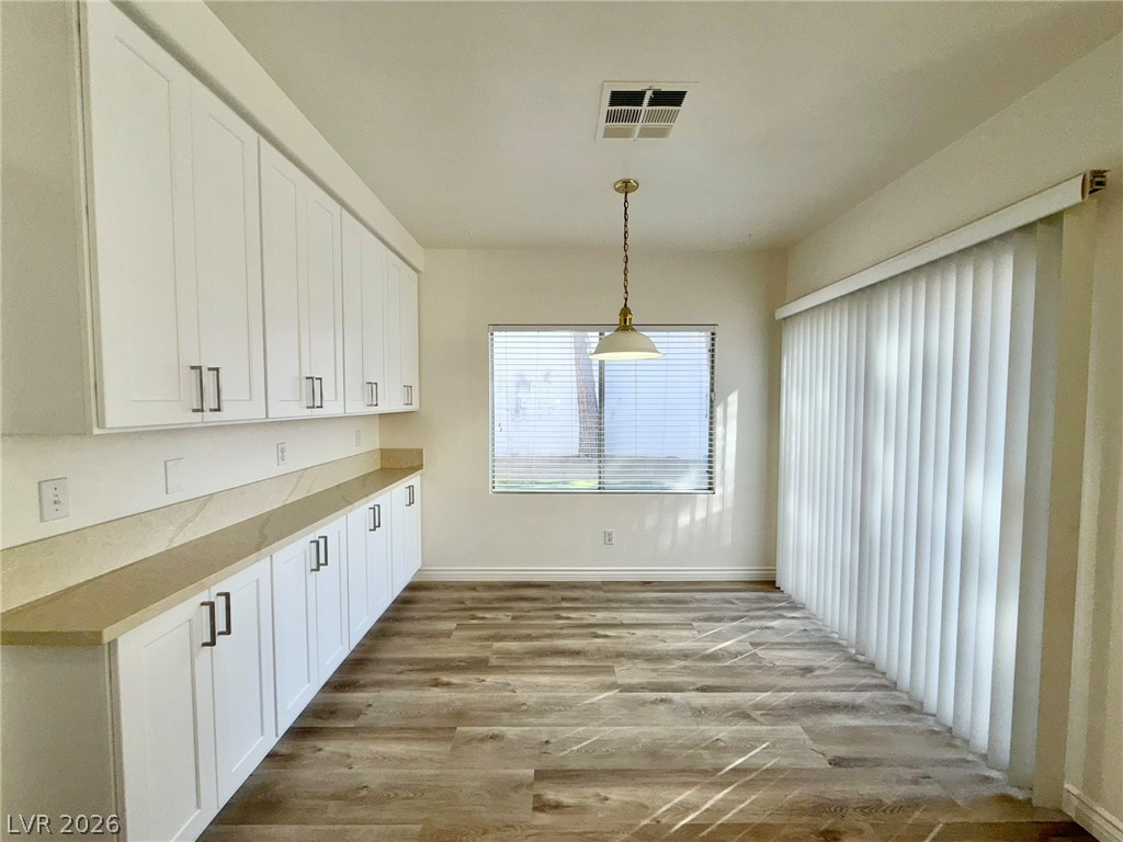 9729 Trail Rider Drive Las Vegas, NV 89117 - Photo 5 of 26 A well-lit area featuring extensive cabinetry, resilient flooring, and an elegant pendant light.