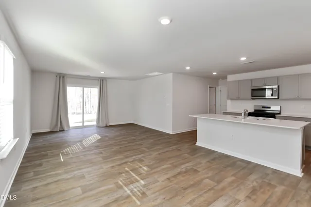 a view of kitchen with wooden floor and electronic appliances