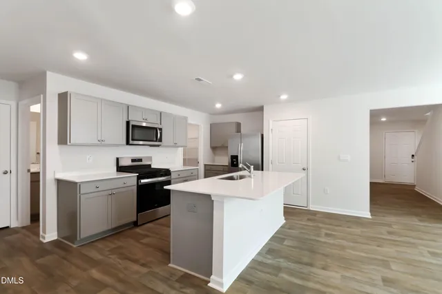 a large white kitchen with a stove top oven
