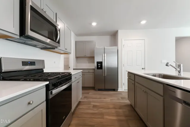 a kitchen with stainless steel appliances granite countertop a stove microwave and refrigerator