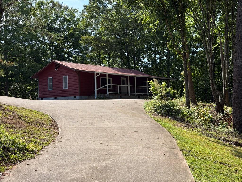 86 Robert Jones Road Dawsonville, GA 30534 - Photo 4 of 19 a front view of a house with a garden