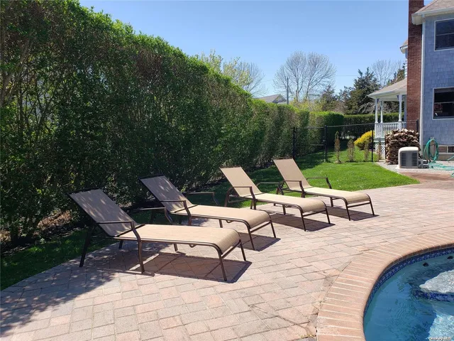 a view of a wooden chairs and table in the patio