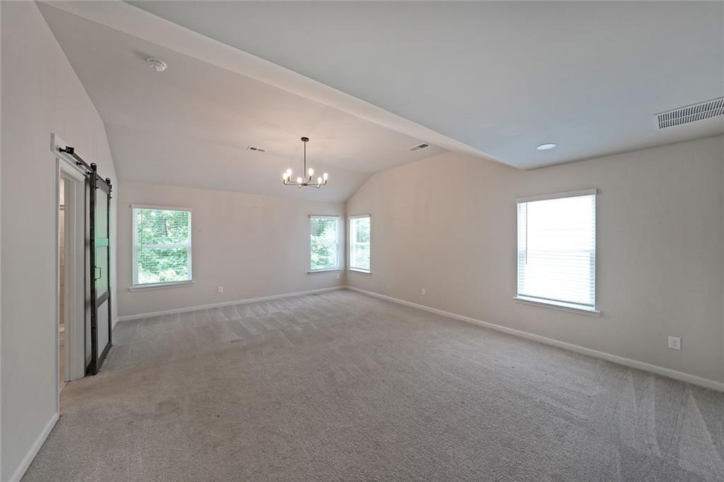 4450 Richmond Court Stone Mountain, GA 30083 - Photo 13 of 31 an empty room with windows and chandelier fan