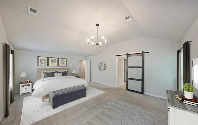 a spacious bedroom with a bed and a chandelier